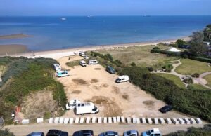 Los viajeros se niegan a pagar al propietario del terreno para que retire los bolardos de hormigón que utilizó para bloquearlos en el estacionamiento de la Isla de Wight, mientras el enfrentamiento entra en el segundo mes