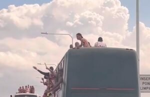 Los fanáticos de Flamengo cruza el puente Rio Desi en el techo del autobús