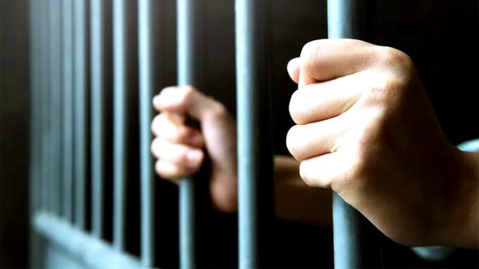 prisoner-hands-behind-jail-bars-istock.jpg